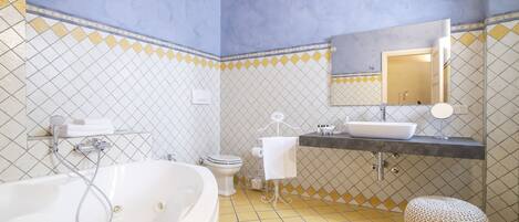 A bathroom with a bathtub, toilet, sink, and mirror.