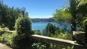 Une balustrade en pierre surplombe un lac sous un ciel dégagé.