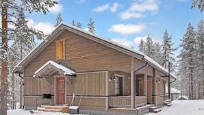Eine Holzhütte mit einer Veranda, einer Haustür und Stufen, die zum Eingang führen.