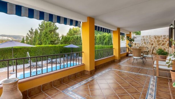 A covered patio with a pool, yellow walls, and outdoor furniture. - Villa San Vicente by Interhome (Córdoba/Baena)