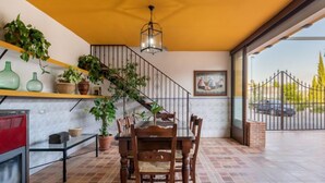 A dining area with a table and chairs, a staircase, and a view of the outside. - Villa San Vicente by Interhome (Córdoba/Baena)