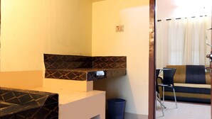 A bathroom with a sink, a blue trash bin, and a towel rack. - City Holidays - Wayanad (Sulthan Bathery)