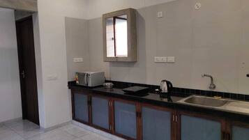 Executive Apartment, 1 King Bed, City View | Private kitchen | Electric kettle, cookware/dishes/utensils, dining tables