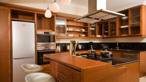 Una cucina moderna con mobili in legno, elettrodomestici in acciaio inossidabile e un'isola centrale.
