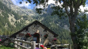 A rustic stone building with a wooden fence, surrounded by lush greenery and mountains in the background. - VALLEY OF GRESSONEY FONTAINEMORE TRILOCALE (Fontainemore)