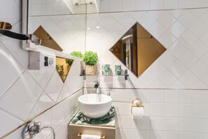 A modern bathroom with a white sink, a mirror, and a shower area. - Homerez - Studio in Menton (Menton)