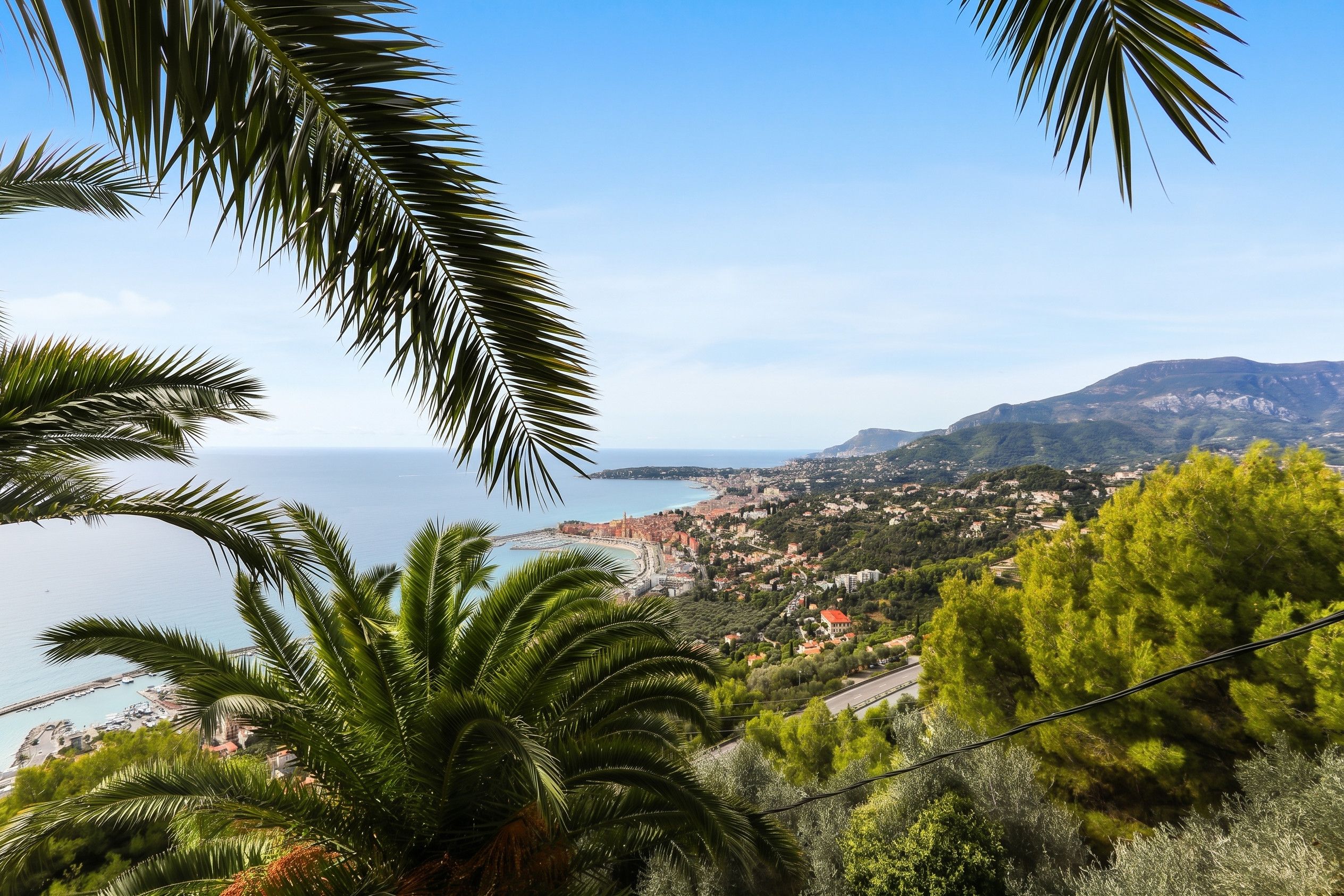 Un paese costiero con vista sul mare e sulle montagne sullo sfondo.