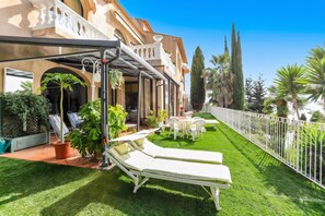 A hotel courtyard with a pool, lounge chairs, and a well-maintained lawn. - Homerez - Studio in Menton (Menton)