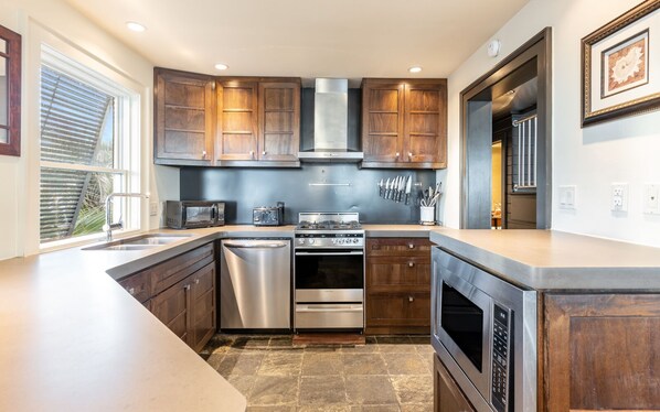 A modern kitchen with wooden cabinets, stainless steel appliances, and a large island. - Gulf Front - Grayton Beach - Next to Red Bar! (Santa Rosa Beach)