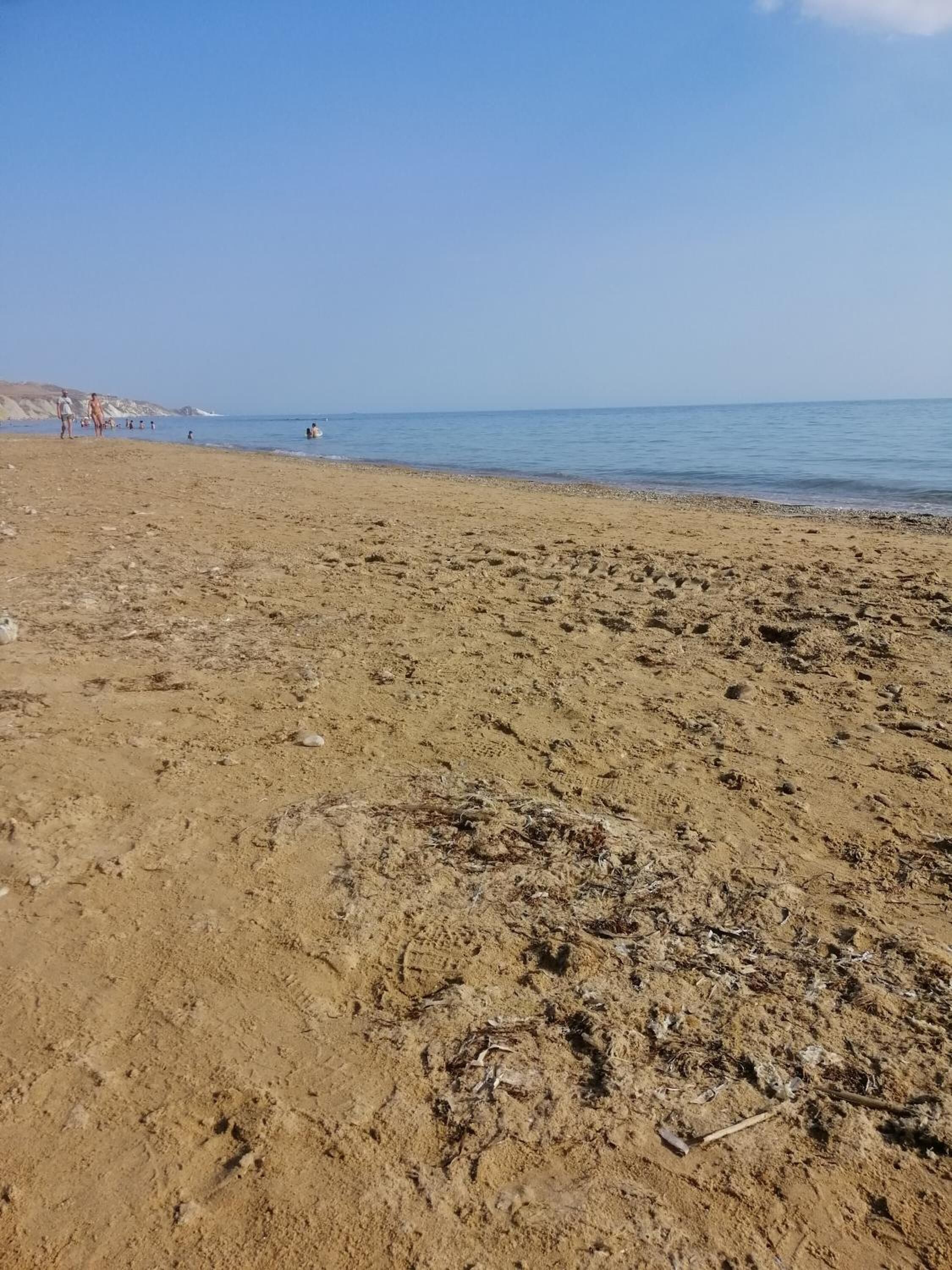 Ein sandiger Strand mit Fußabdrücken und ein wenig Treibgut.