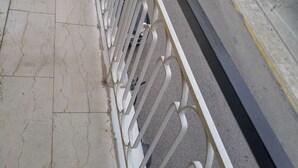 Ein Balkon mit Metallgeländer und Blick auf eine Straße.