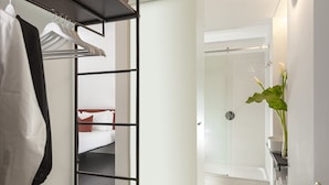 A hotel room with a bed, a wardrobe, and a bathroom with a shower and a sink. - Maison Ottavia (Rome)