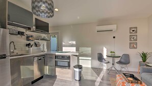 A modern kitchen with stainless steel appliances, a central island, and a dining area with a round table and chairs.
