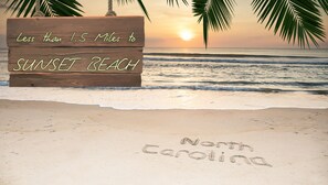 Un letrero de madera que dice "Menos de 2.4 kilómetros a Sunset Beach" y "Carolina del Norte".