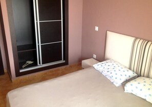 Un dormitorio con cama, ventana y armario.
