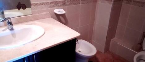 Un baño con lavamanos, bidé e inodoro.