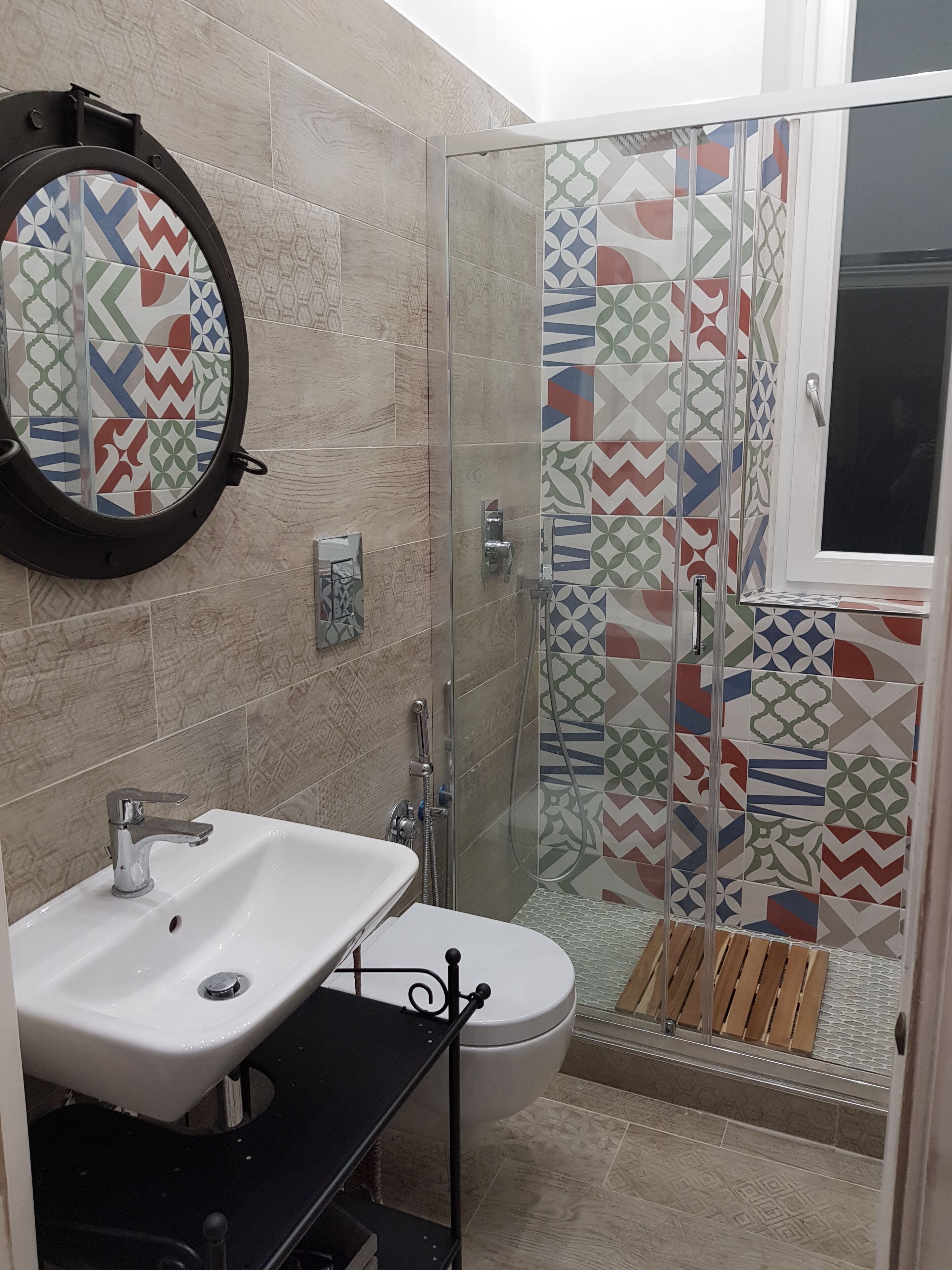 A bathroom with a sink, toilet, and shower area.