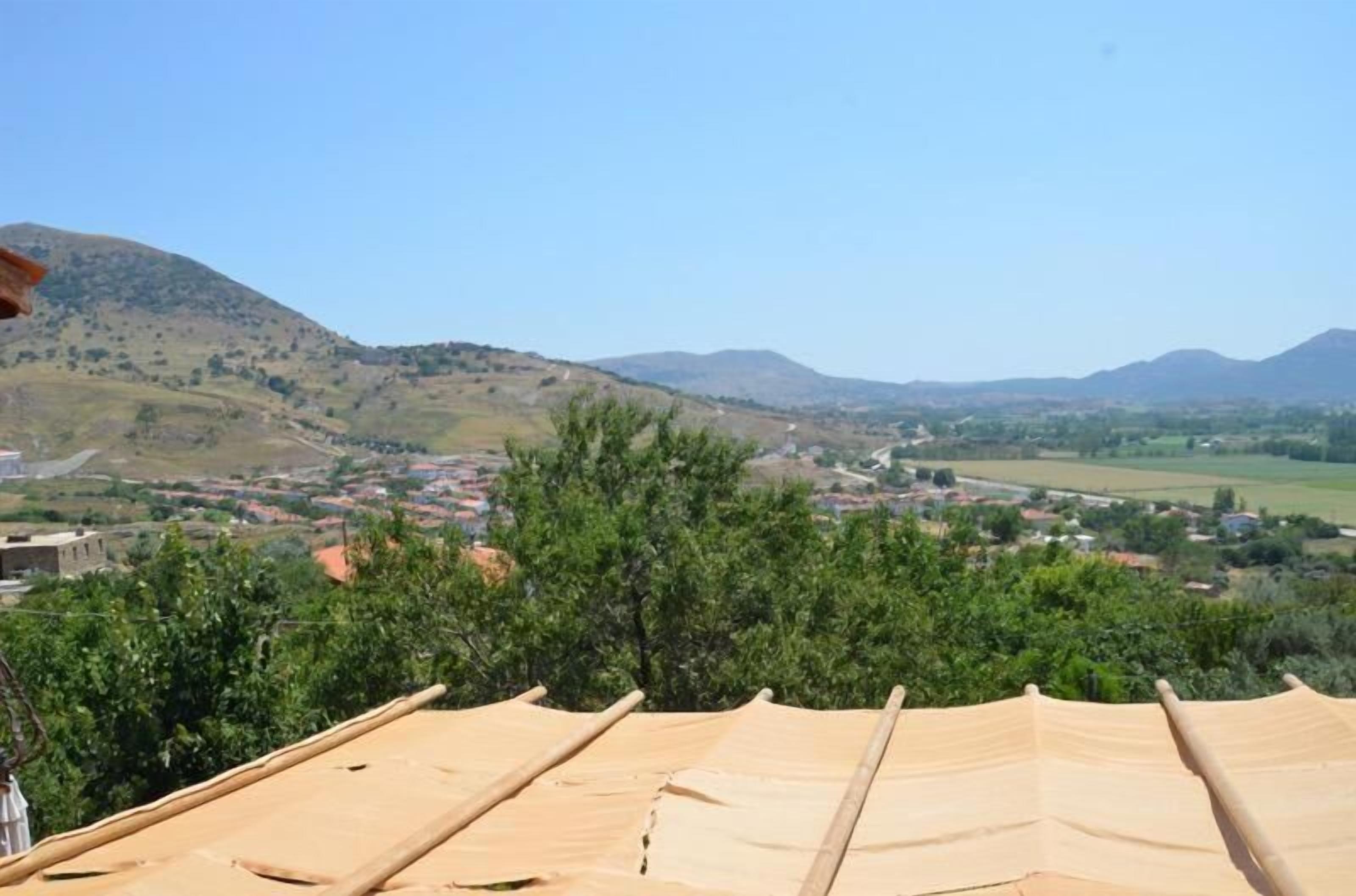 A view from a high vantage point overlooking a valley with a town and hills in the distance.