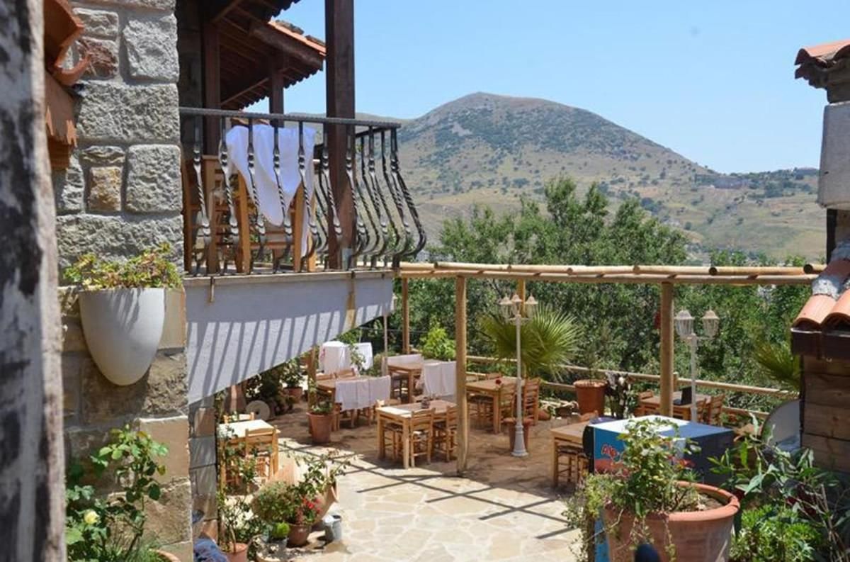 Un edificio de piedra con un balcón de madera que da a un paisaje montañoso.