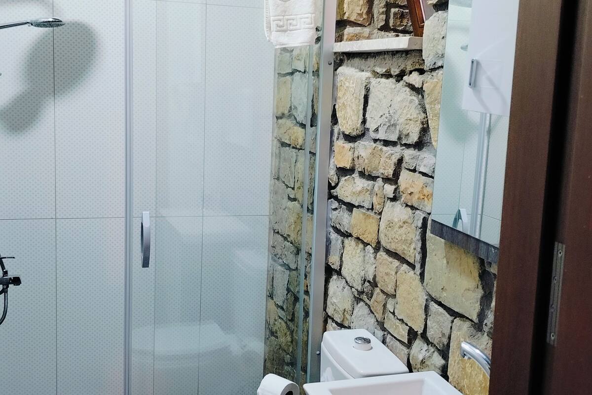 A bathroom with a shower, toilet, and sink.