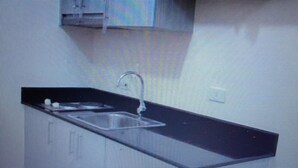 Ein Zimmer mit einem großen Fenster, einem schwarzen Schrank und einem schwarzen Stuhl.