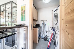 A compact kitchen with a washing machine, a drying rack, and a coffee machine. - Faronniere 5 : Duplex 3 bedrooms in village heart (MORZINE)