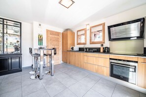 A modern kitchen with a built-in oven, microwave, and stainless steel appliances.