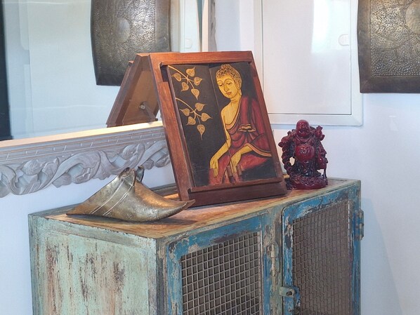A framed painting of a seated figure on a rustic blue cabinet with a decorative metal object on top. - VILLA LOFT BOUDDHA HOUSE, 50 M. SEA, HEATED POOL / JACUZZI, PRIVATE * (SAINT AYGULF / FREJUS)