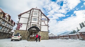 A building with a sign reading "Mili & Jon" and a stone facade. - Hotel Milli & Jon (Bukovel)