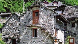 A stone building with a small balcony and a window.