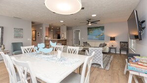 A spacious living room with a dining area, a kitchen in the background, and a painting on the wall. - Beachy Getaway–Cozy, Clean & Equipped w/ All Essentials! Relax, Enjoy & Refresh! (St. Augustine)