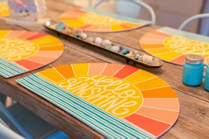 Een tafel met een kleurrijke tafelonderzetter en een schaal decoratieve items.