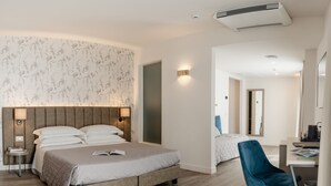 A modern hotel room with a large bed, a desk, and a chair. - Hotel Du Lac Gardone Riviera (Gardone Riviera)