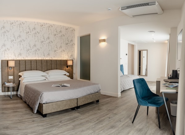 A modern hotel room with a large bed, a desk, and a chair. - Hotel Du Lac Gardone Riviera (Gardone Riviera)