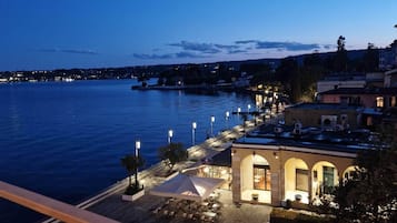 Propiedad frente al agua con asientos al aire libre, un edificio con arcos y vista al mar.