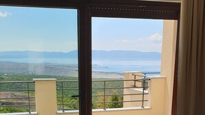 A modern living room with a large sliding glass door leading to a balcony with a scenic view. - "Nilaria" sea view apartment & pool near Krk, Rijeka (Bakar)
