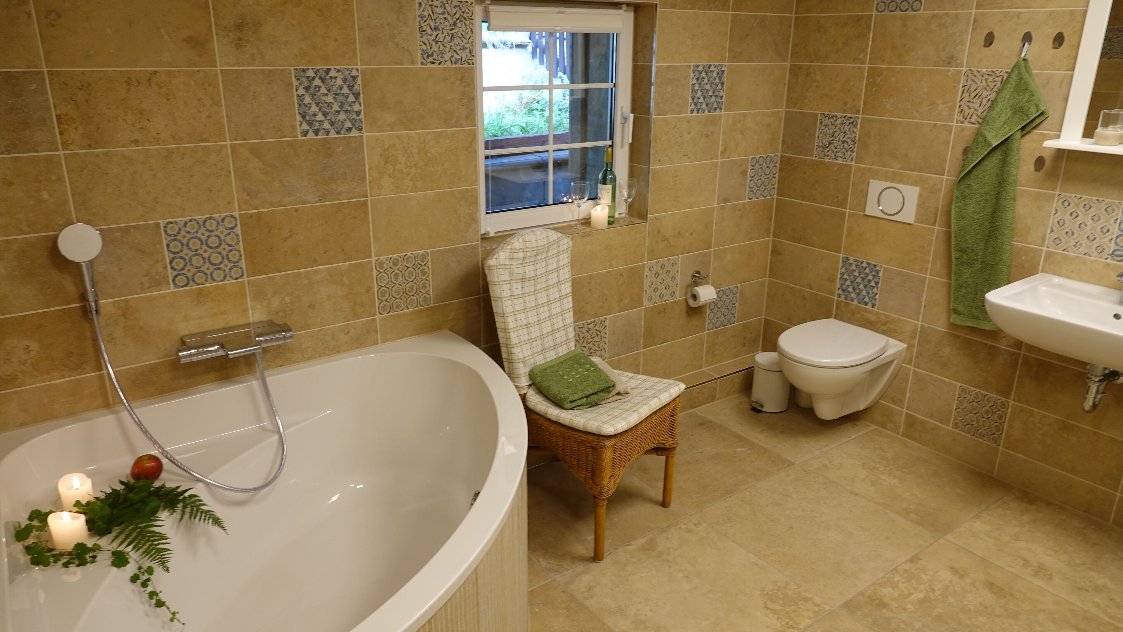 Ein Badezimmer mit einer Badewanne, einer Toilette, einem Waschbecken und einem Fenster.