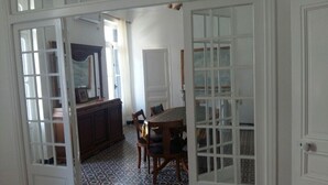Een eetruimte met een tafel en stoelen, een kast en een vloer met een patroon.