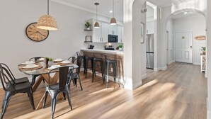 A modern kitchen with white cabinets, a central island, and pendant lighting.