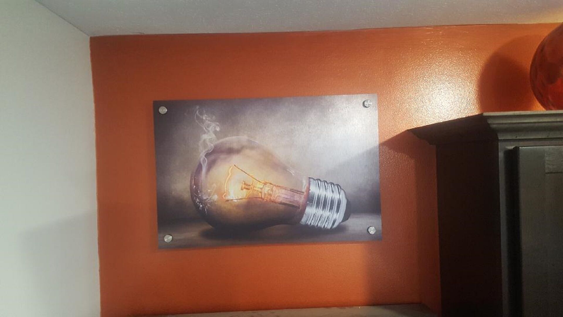 Una pared con un cuadro de una bombilla.