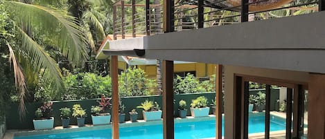 Una piscina al aire libre, tumbonas, socorrista en las instalaciones