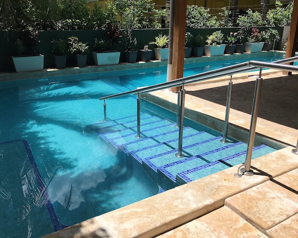 Outdoor pool, pool loungers, lifeguards on site