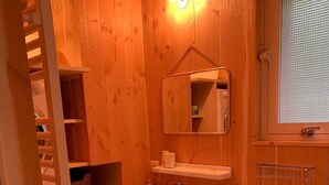 A wooden bathroom with a sink, mirror, and shelves. - Wooden house in the center of Cap Ferrets ans a quiet street 100 m from the market. (Lège-Cap-Ferret)