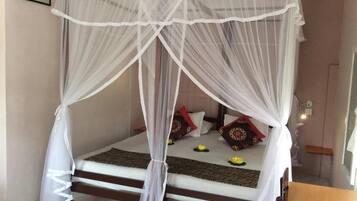 A bed with a canopy, pillows, and a small table.