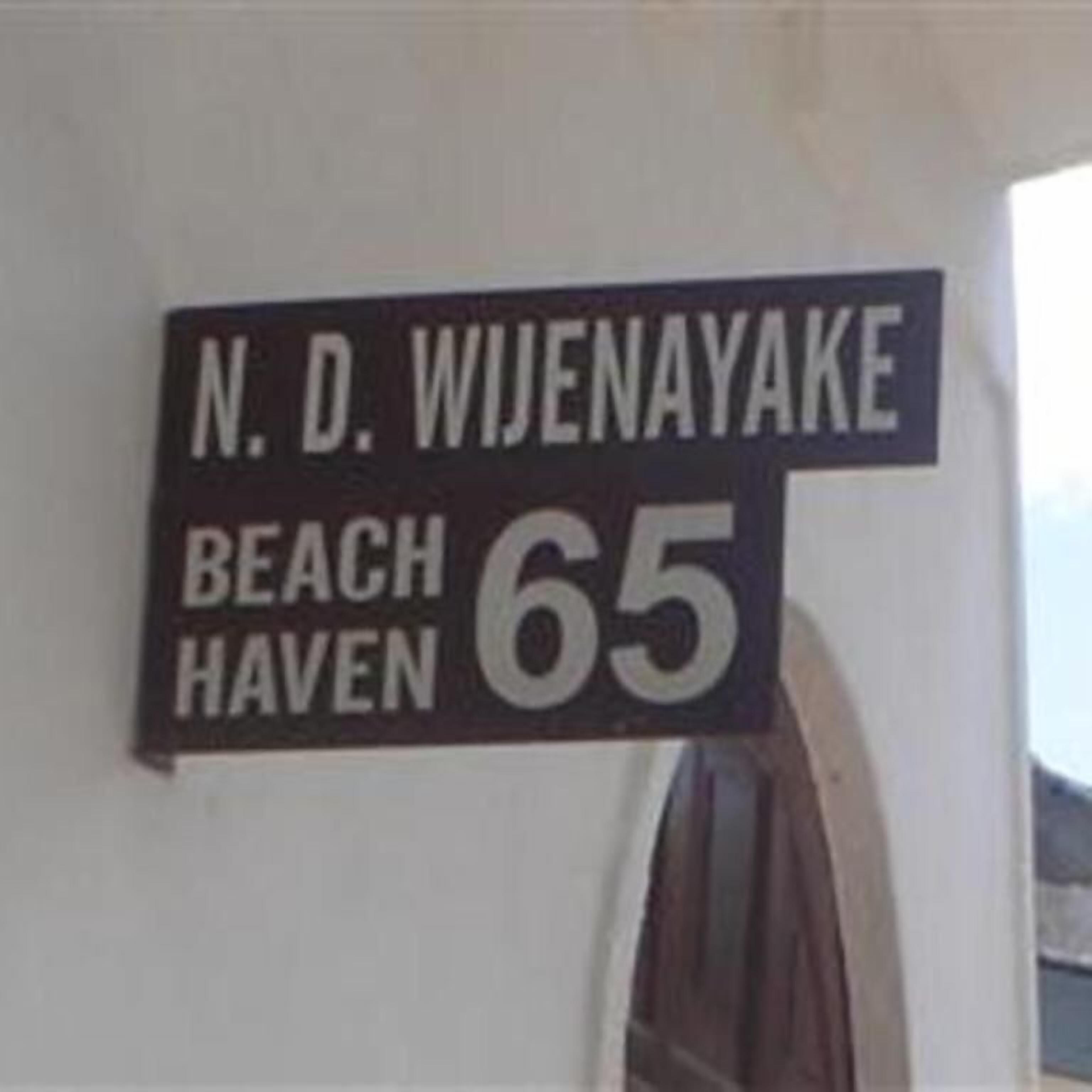 A sign with the text "N. D. WIJENAYAKE BEACH HAVEN 65".