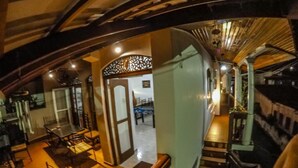 Un vestíbulo de hotel con una escalera, un mostrador de recepción y un comedor.