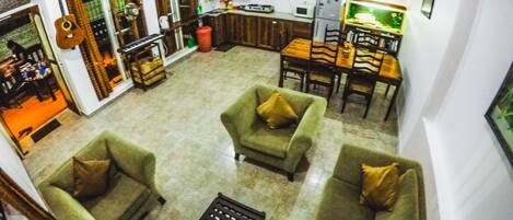 A spacious living room with a sofa set, a coffee table, and a dining area with chairs and a table.