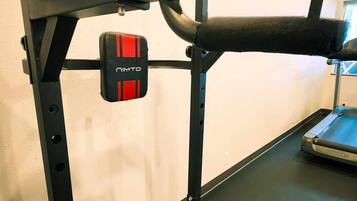 A gym with a weight bench, a squat rack, and a bench press.