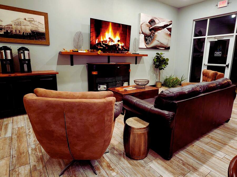 Ein Wohnzimmer mit Kamin, Ledersofas, einem Couchtisch und einem Fernseher.