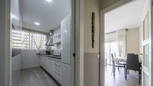 A modern kitchen with white cabinets and a dining area with a table and chairs.